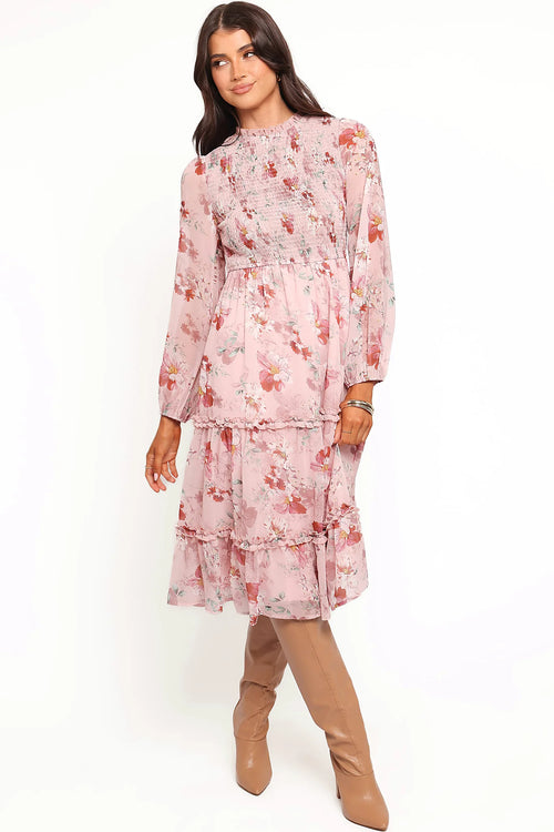 Back view of a pink pink floral midi dress, sheer sleeves, worn by a model against a plain studio backdrop