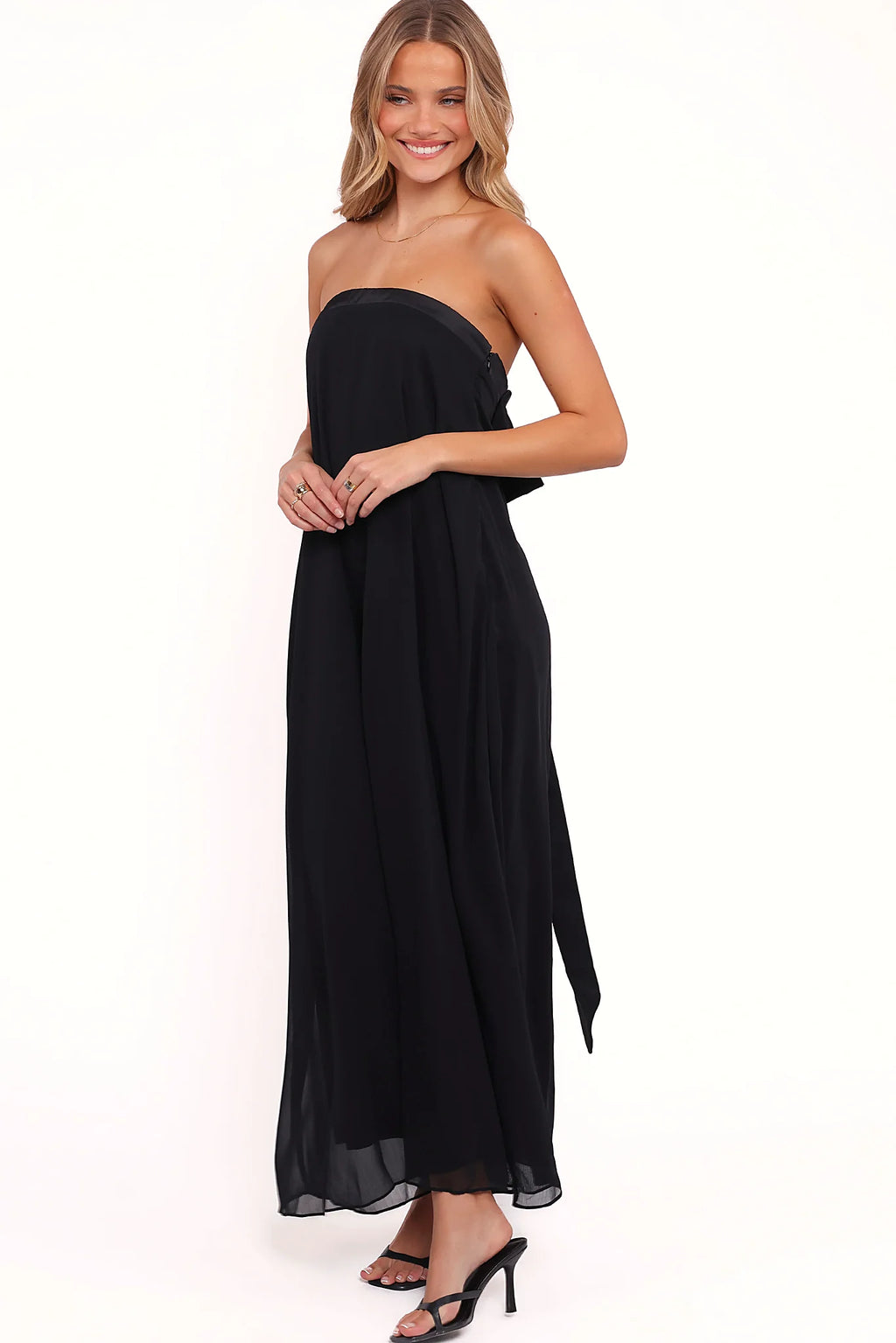 Close-up detail of a black strapless black maxi dress, bow back, showing the fabric and hem finish