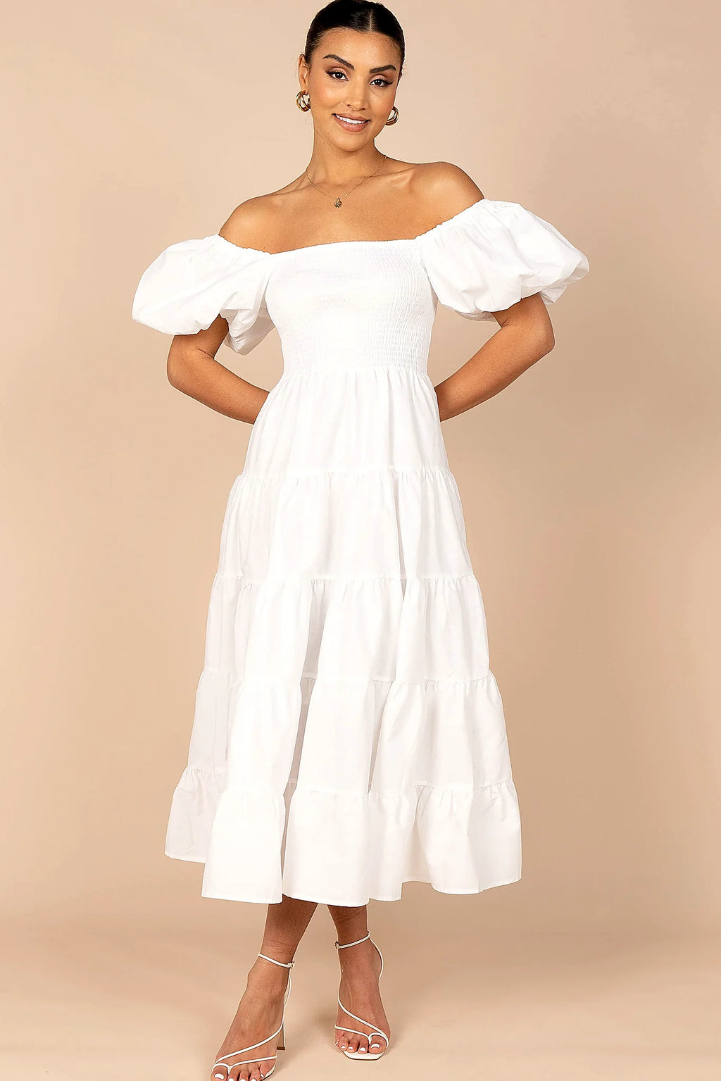 Front view of a white white smocked puff sleeve midi dress, showing the fabric and hem finish