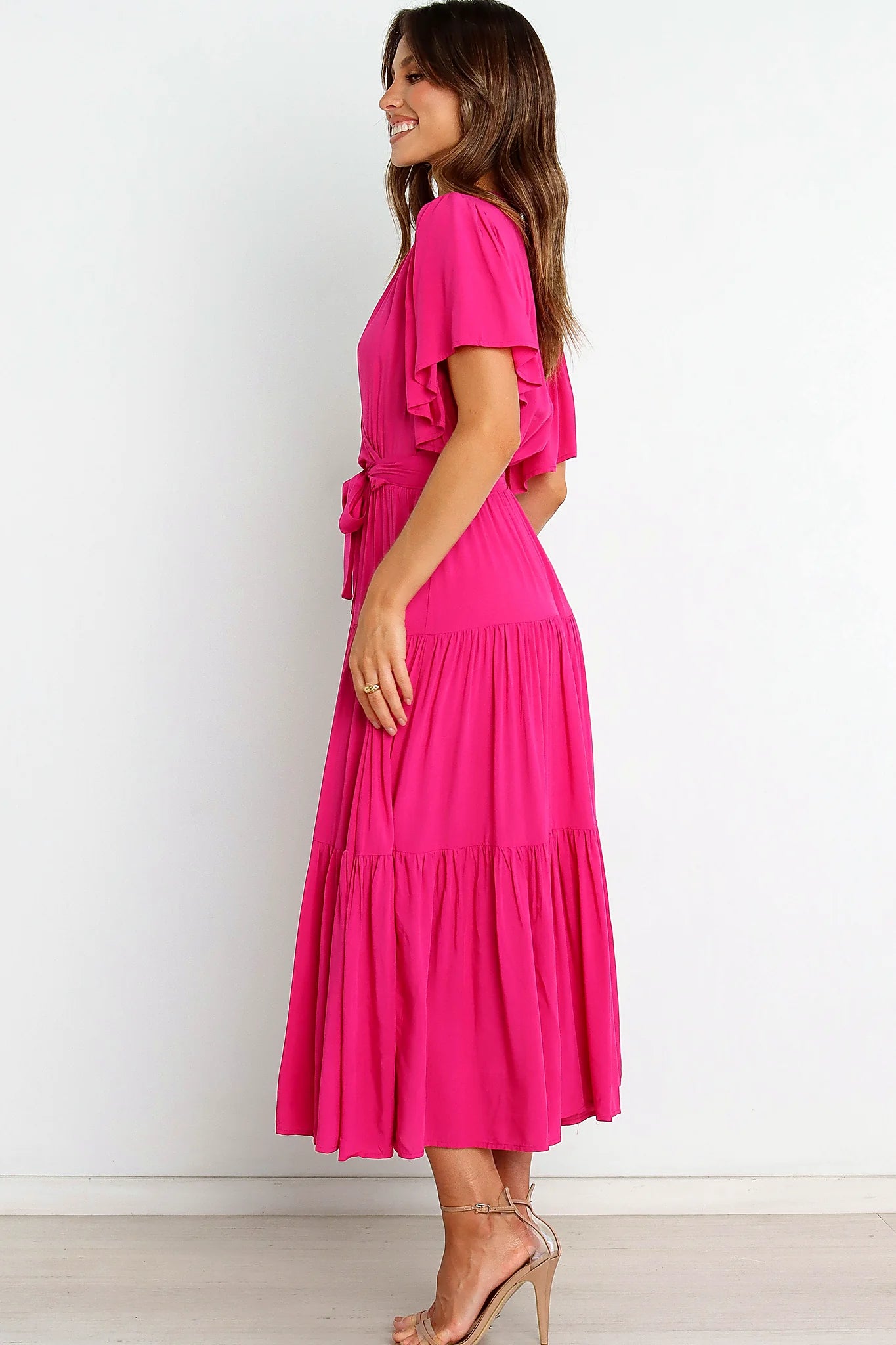 Close-up detail of a pink pink ruffle sleeve tiered midi dress, showing the fit and drape of the skirt