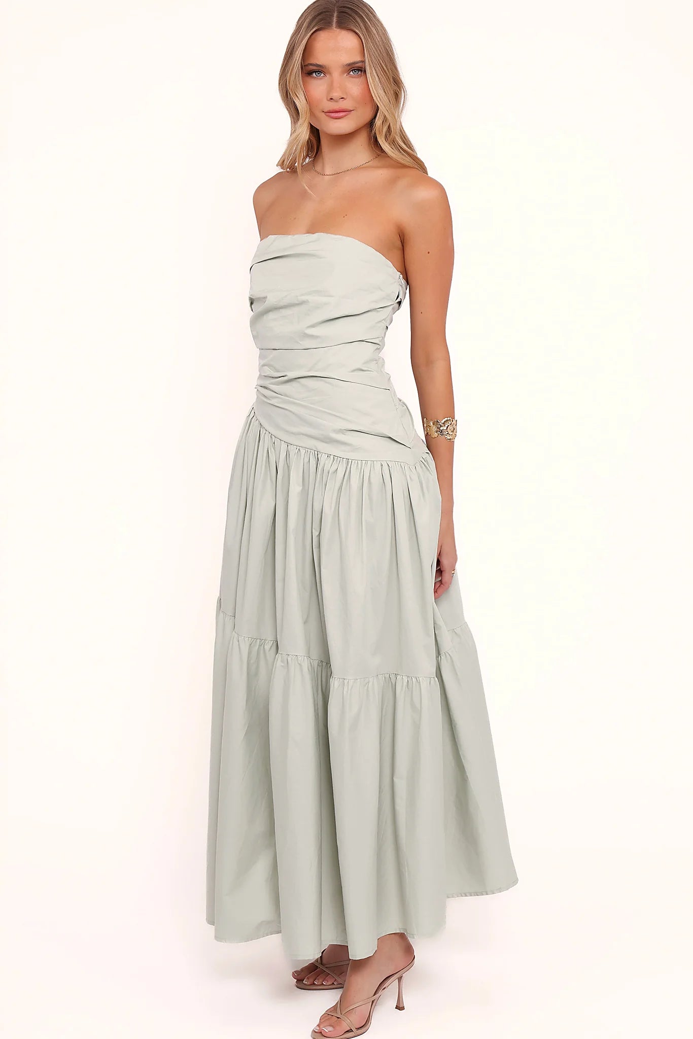 Side view of a mint strapless maxi dress, tiered skirt, showing the fabric and hem finish