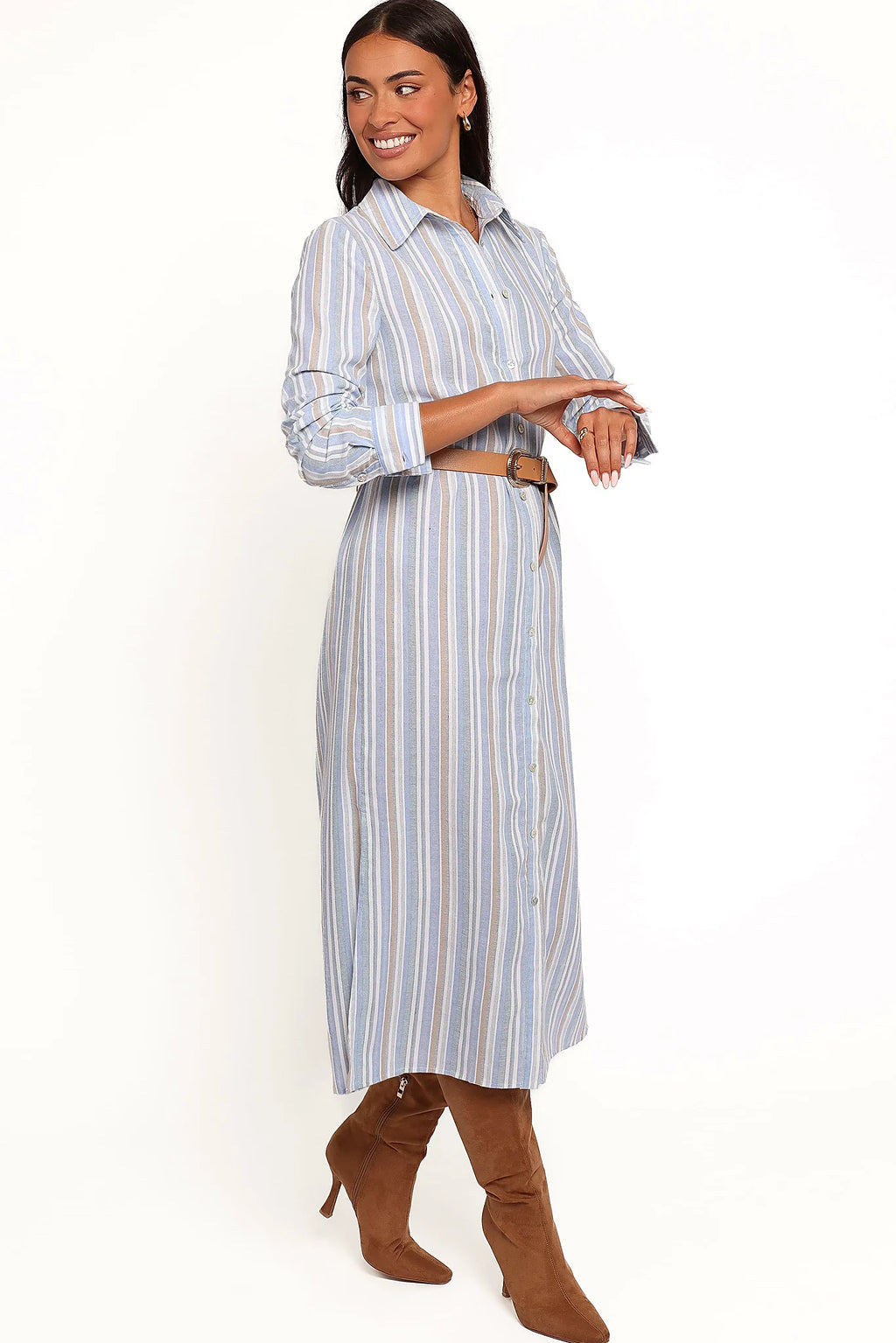 Side view of a blue blue stripe button down maxi shirt dress, worn by a model against a plain studio backdrop