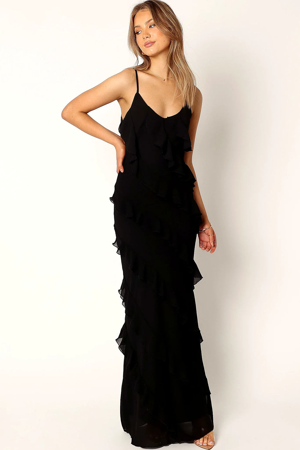 Back view of a black black ruffle maxi dress, v back, showing the fit and drape of the skirt
