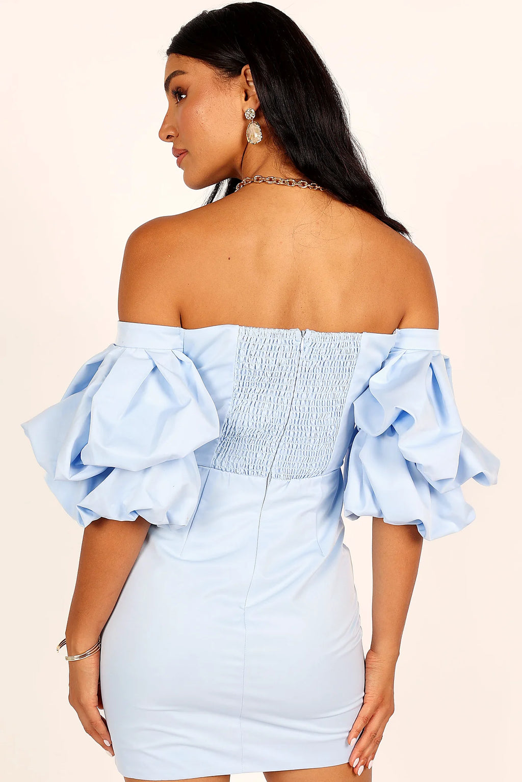 Close-up detail of a icy blue puff sleeve mini dress, showing the fabric and hem finish