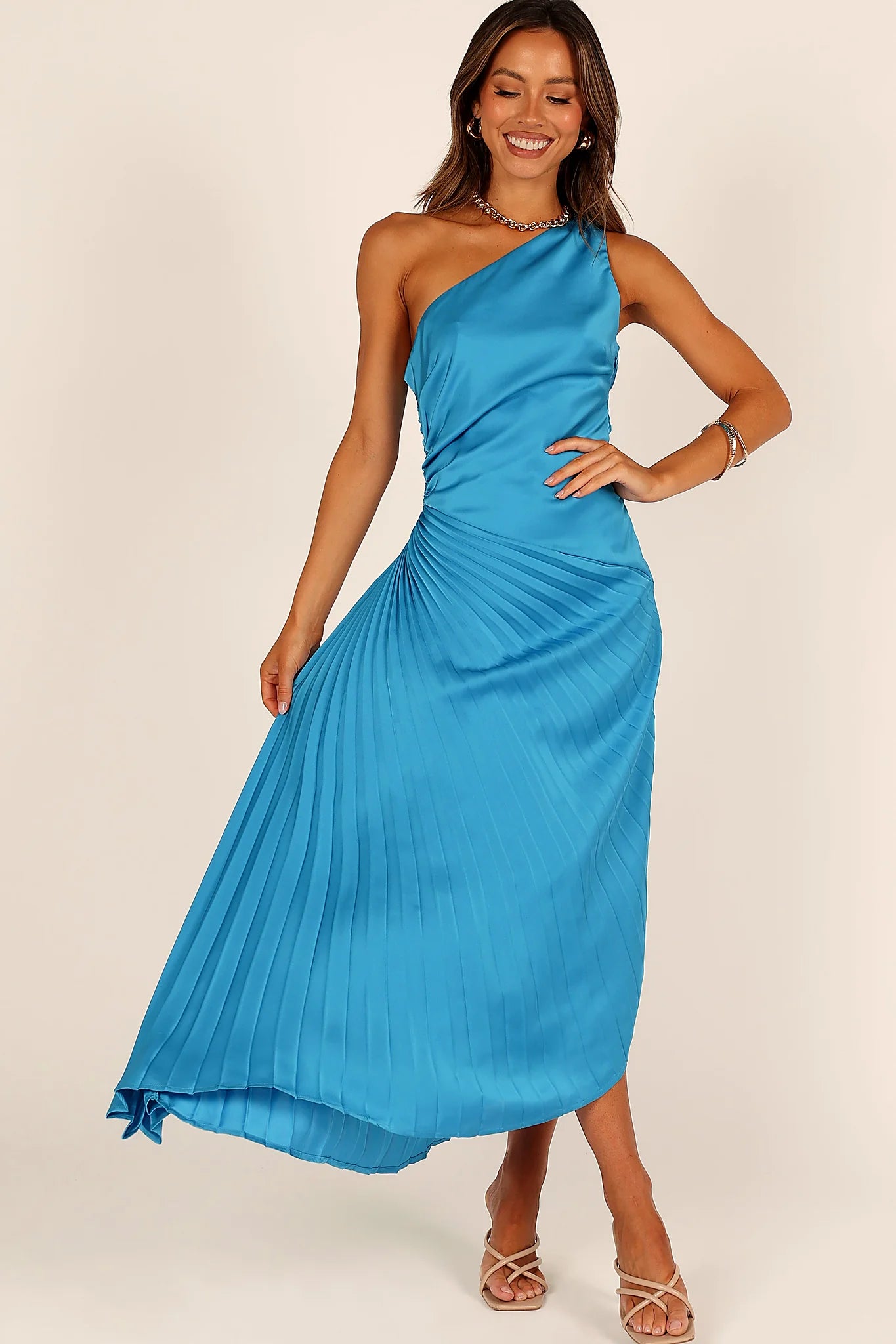 Side view of a blue blue one shoulder pleated midi dress, showing the neckline and bodice detail