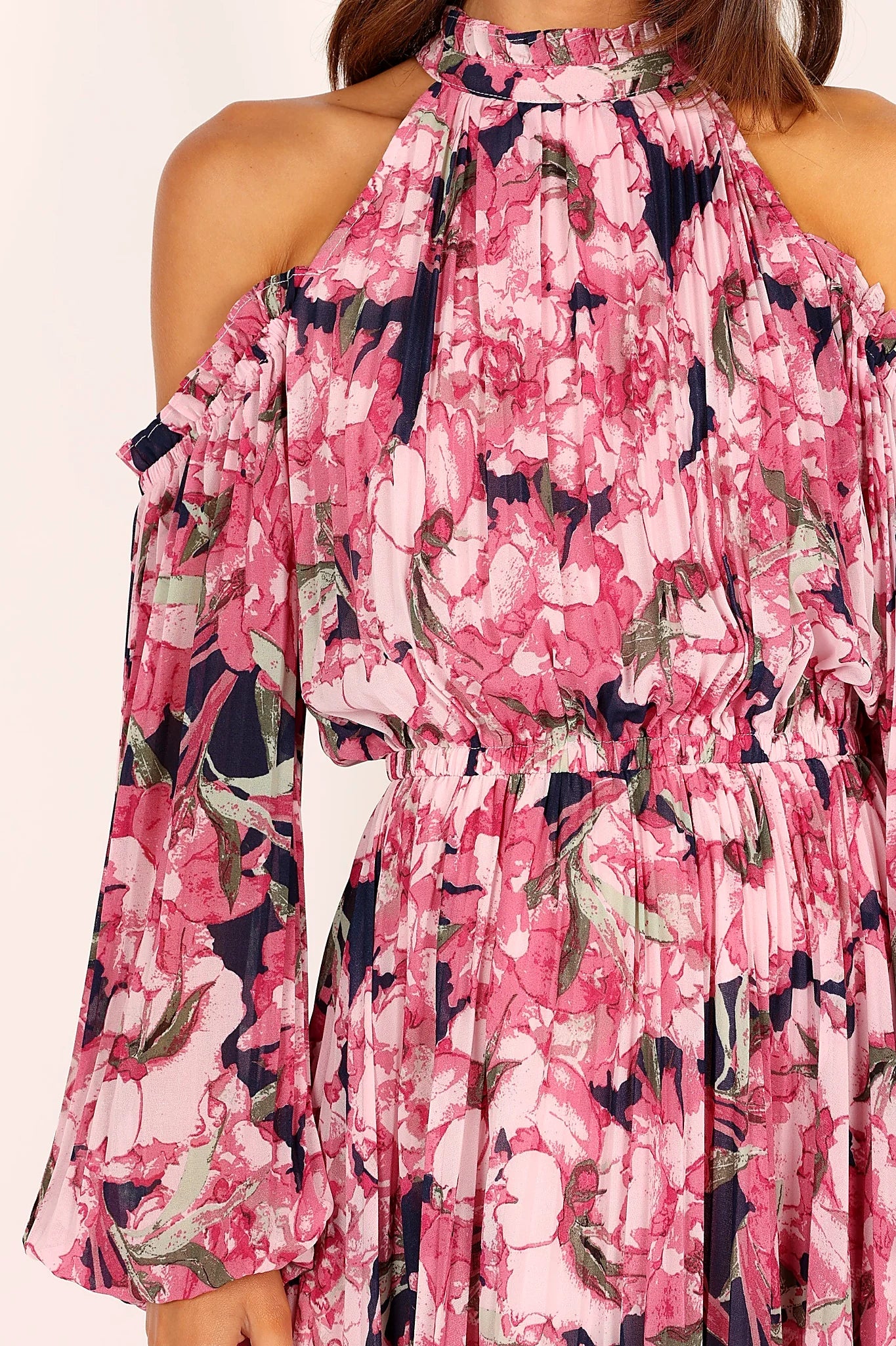 Side view of a pink pink floral pleated maxi dress, showing the fabric and hem finish