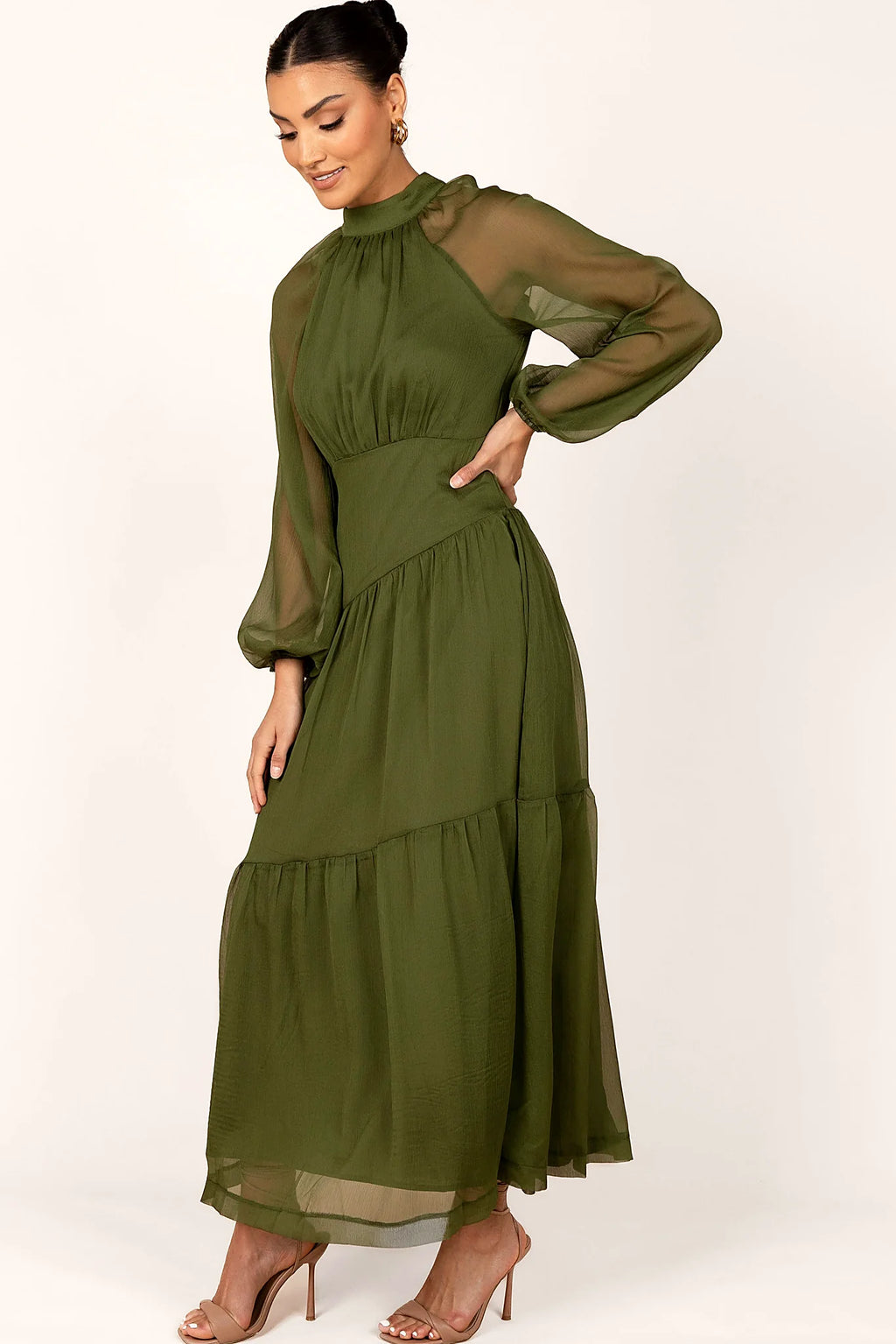 Side view of a olive maxi dress with sheer sleeves, showing the fit and drape of the skirt
