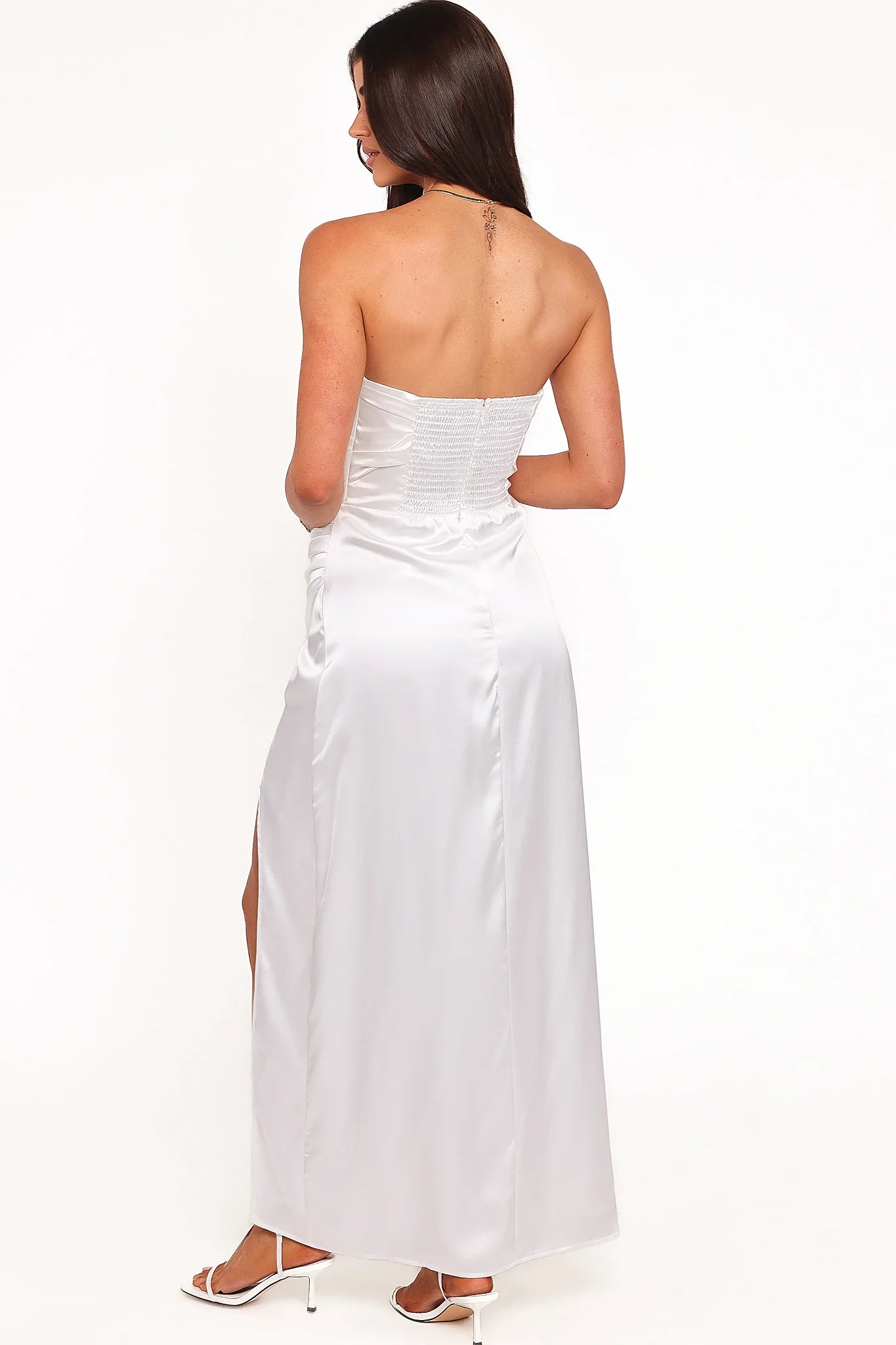 Side view of a white strapless maxi dress, showing the fabric and hem finish