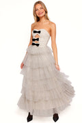 Front view of a black cream polka dot strapless midi dress, worn by a model against a plain studio backdrop