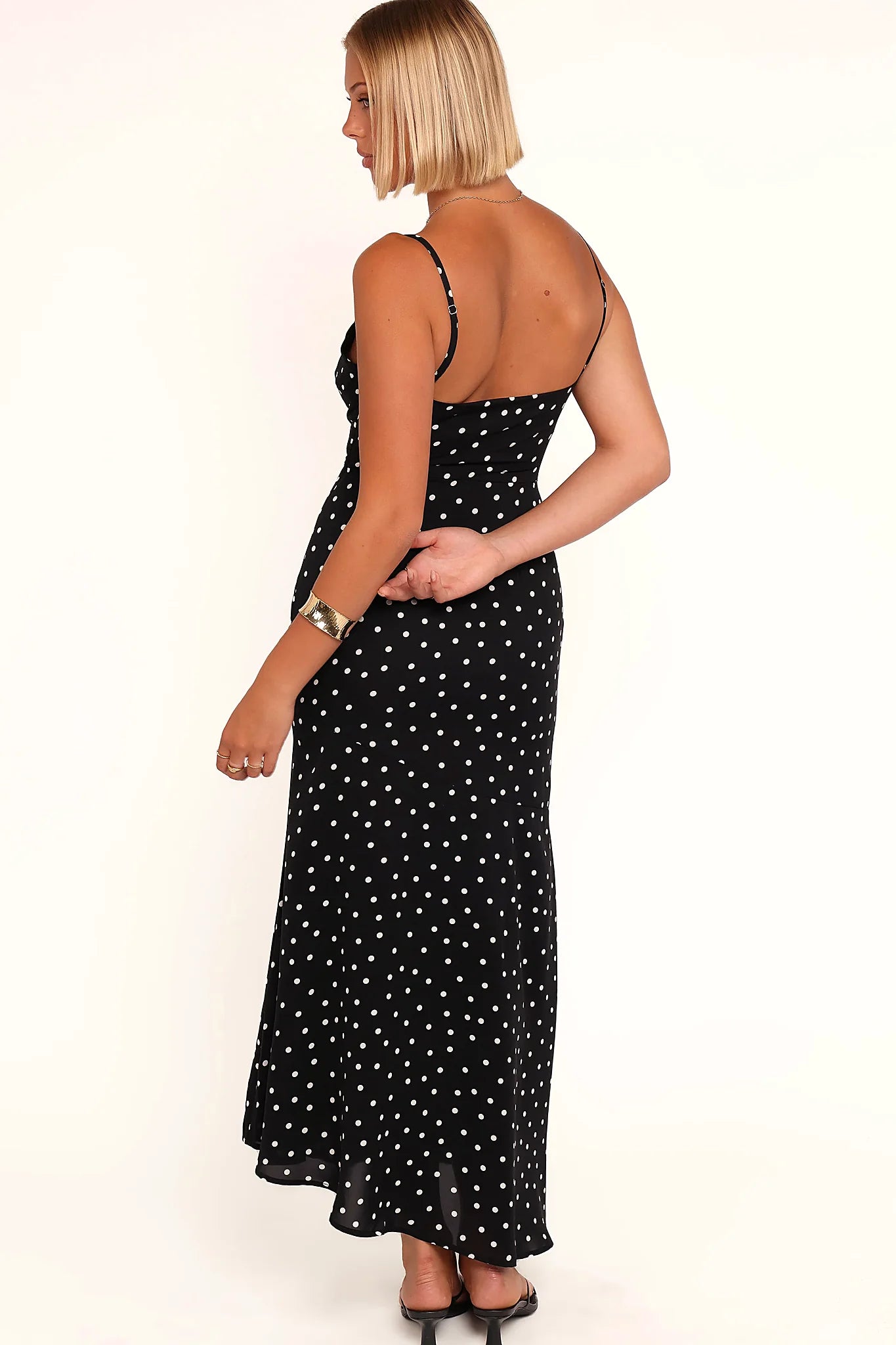 Close-up detail of a black polka dot midi dress, showing the neckline and bodice detail