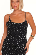 Front view of a black polka dot midi dress, showing the fabric and hem finish