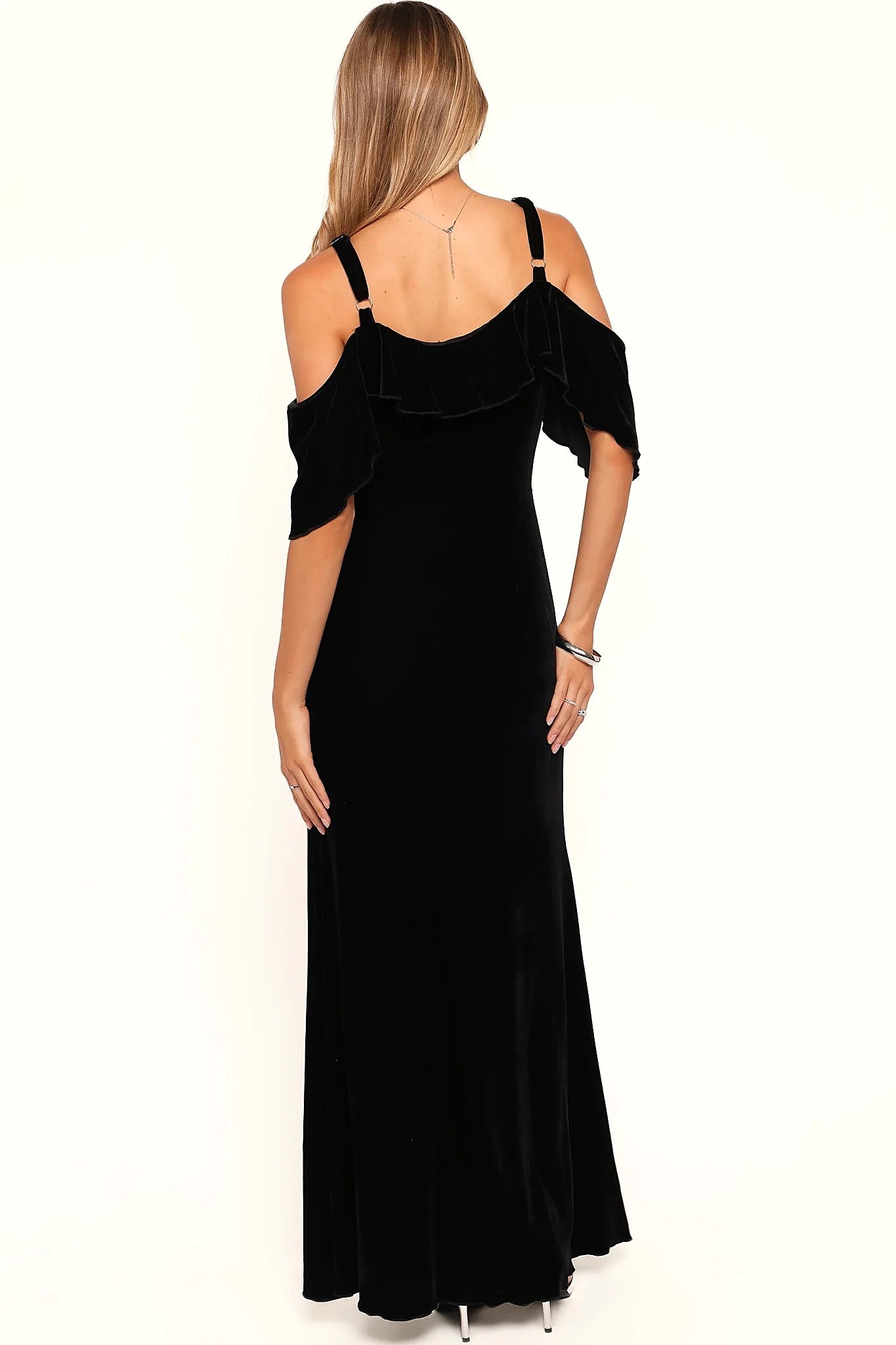 Close-up detail of a black off shoulder velvet maxi dress, showing the fabric and hem finish