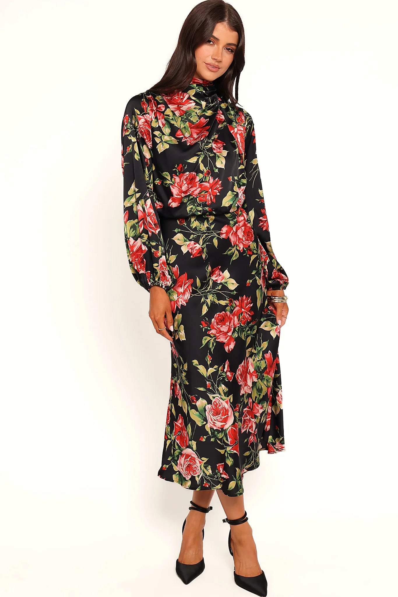 Back view of a black black floral midi dress, open back, worn by a model against a plain studio backdrop