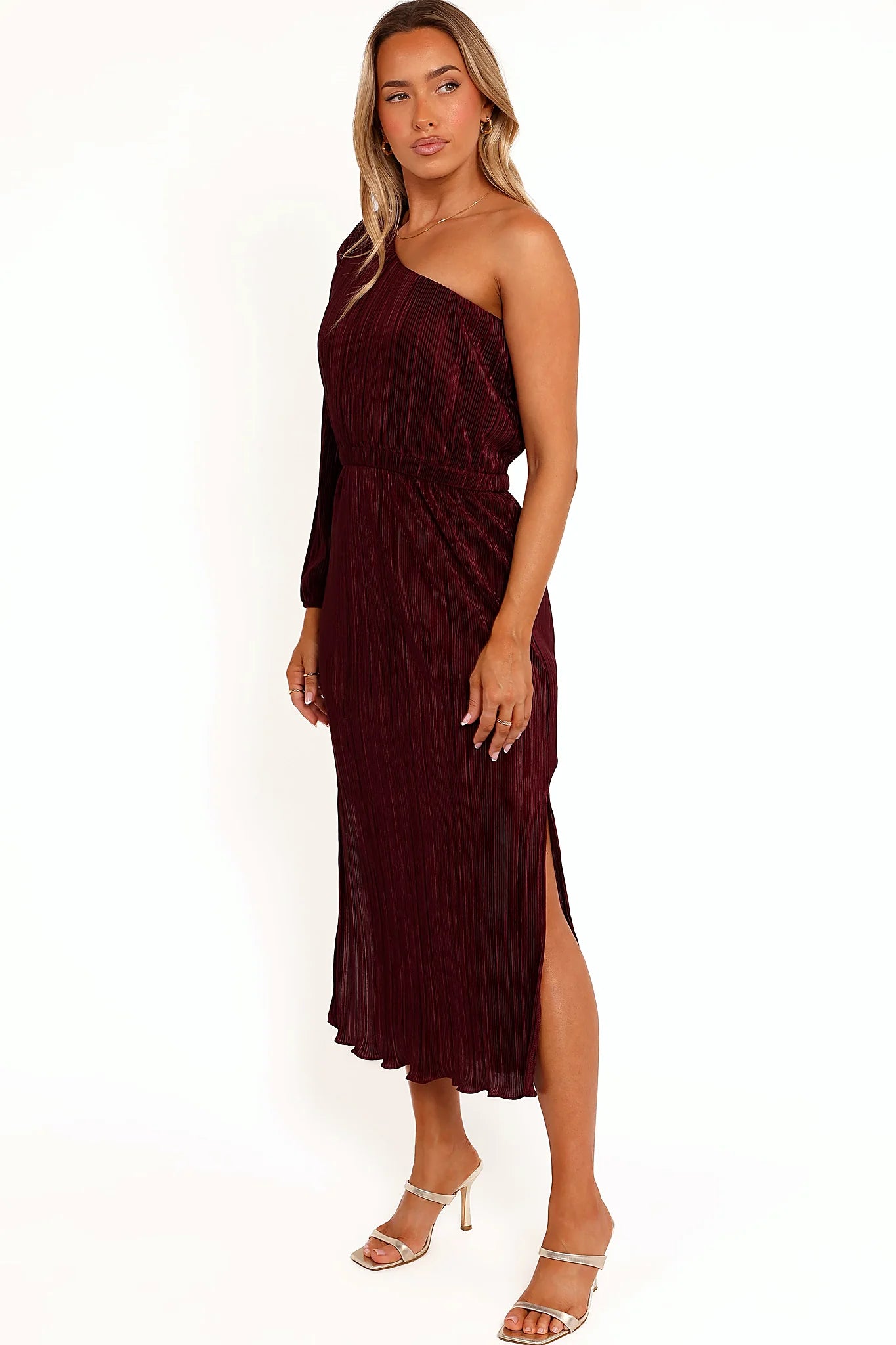 Close-up detail of a red burgundy one shoulder pleated midi dress, showing the fit and drape of the skirt
