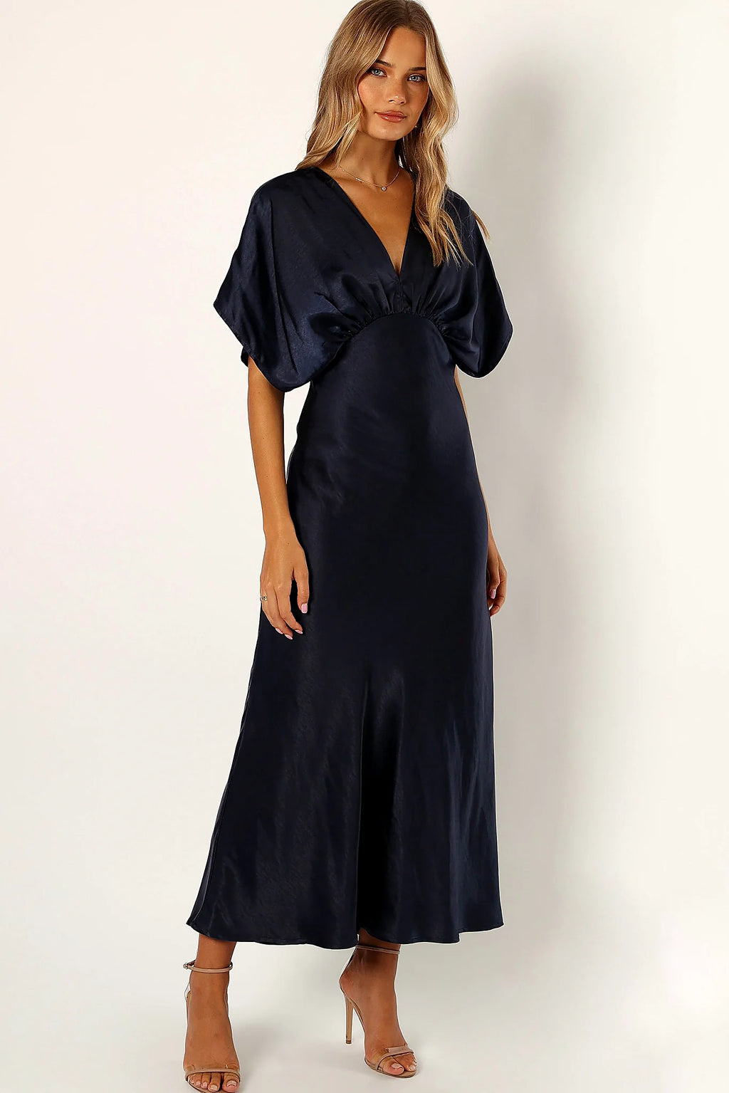 Back view of a navy satin maxi dress in midnight indigo, worn by a model against a plain studio backdrop