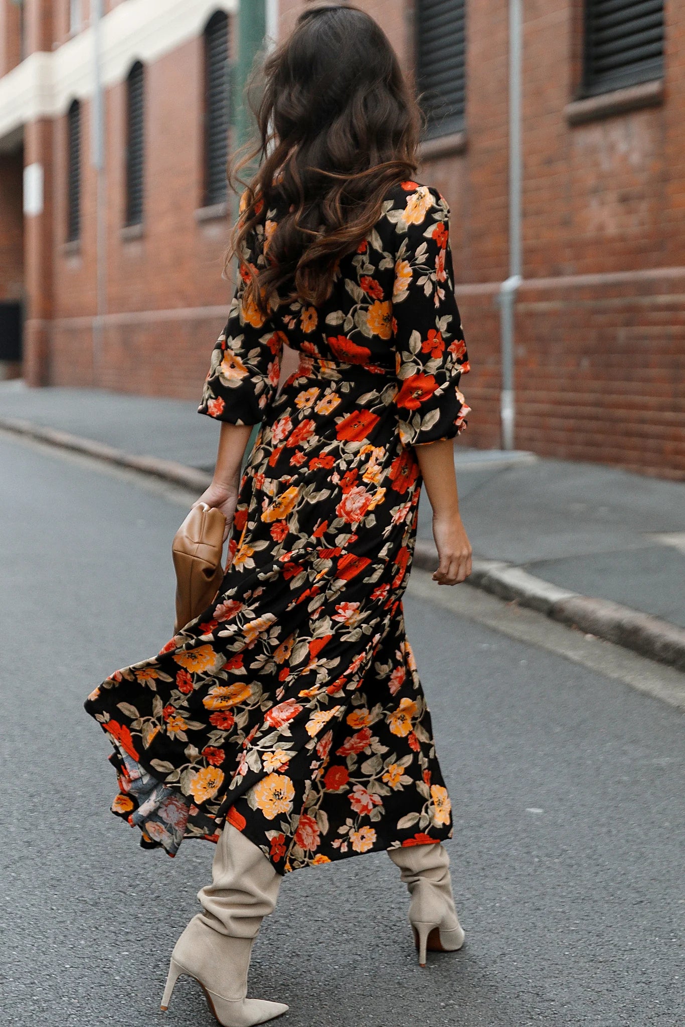 Back view of a black black floral tiered maxi dress, showing the fit and drape of the skirt