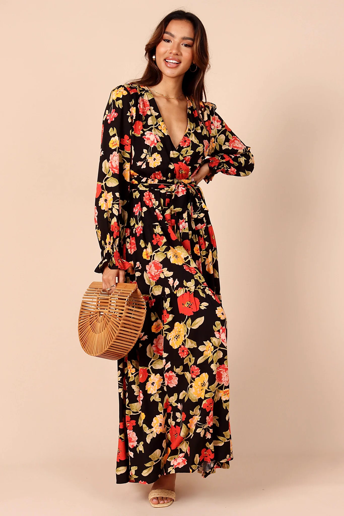 Side view of a black black floral tiered maxi dress, showing the neckline and bodice detail