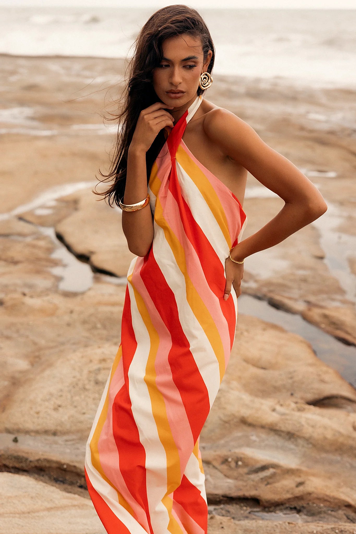Back view of a pink stripe maxi dress, worn by a model against a plain studio backdrop