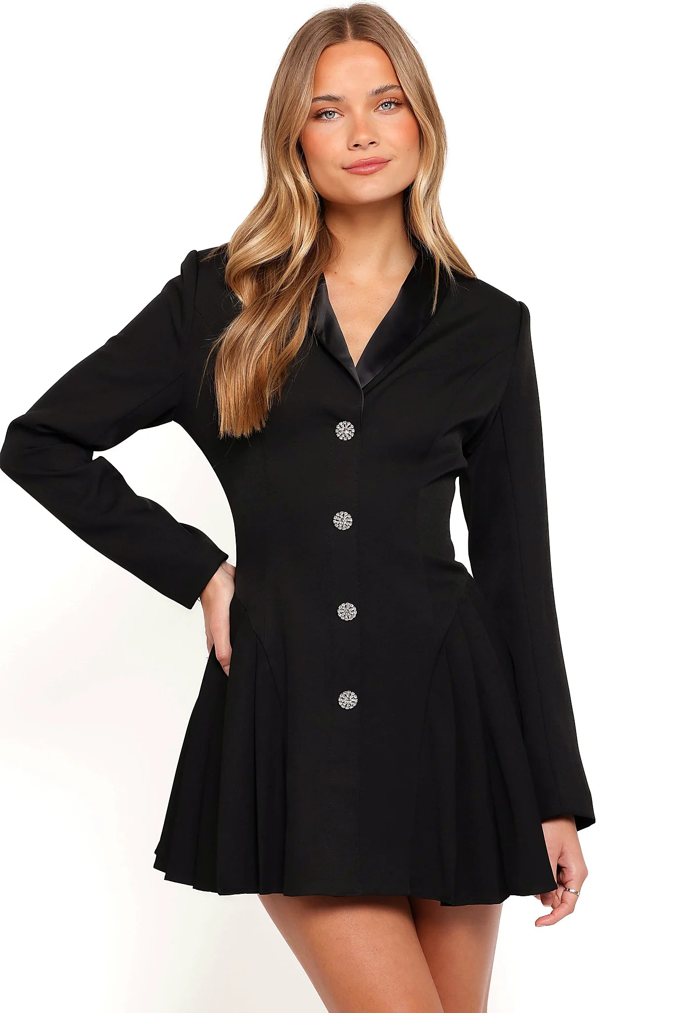 Back view of a black black mini dress, padded shoulders, showing the fit and drape of the skirt