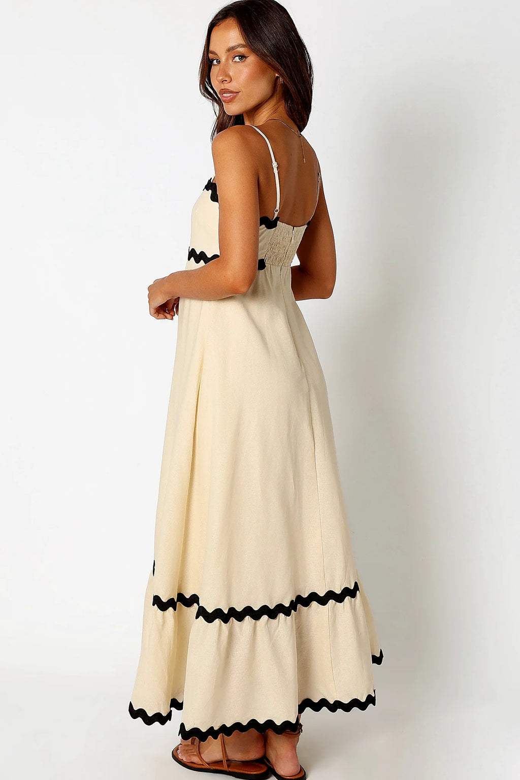 Side view of a black cream & black relaxed maxi dress, showing the neckline and bodice detail