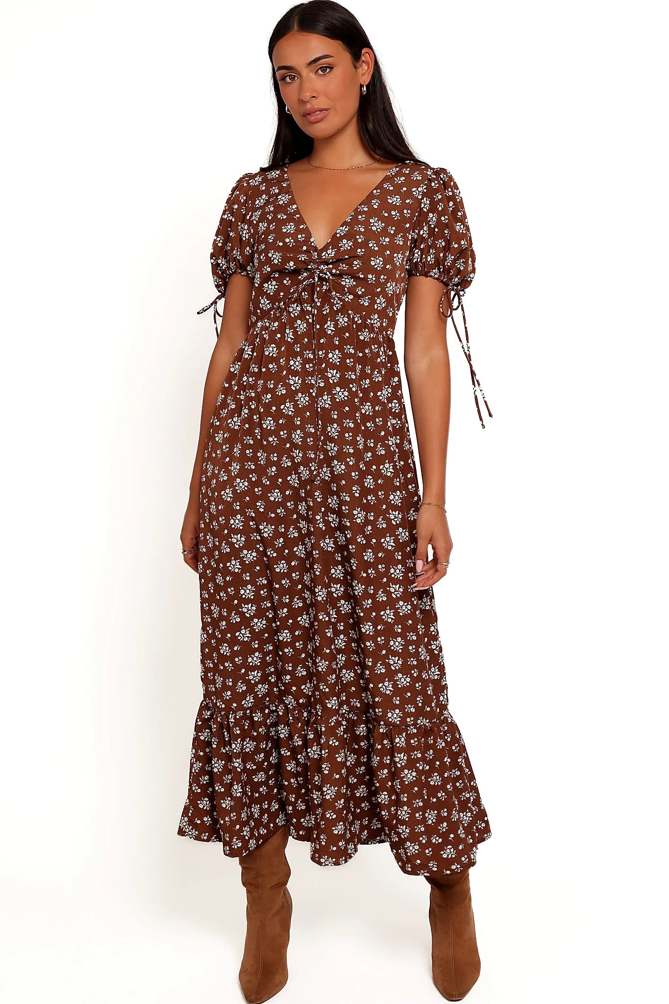 Back view of a brown ditsy floral maxi dress, worn by a model against a plain studio backdrop