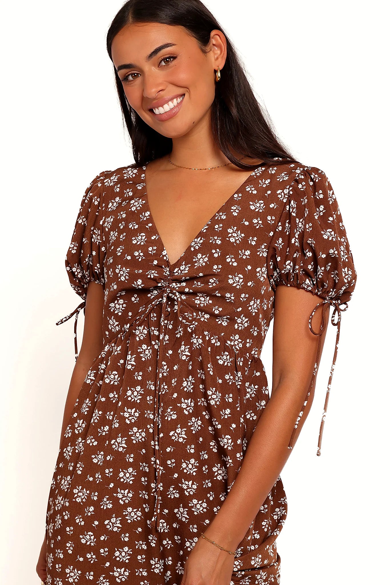 Front view of a brown ditsy floral maxi dress, showing the fabric and hem finish